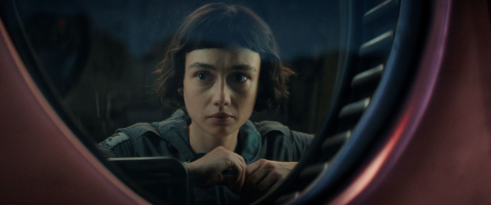 Wendy (Sydney Chandler) observe derrière une vitre ronde dans la série Alien: Earth