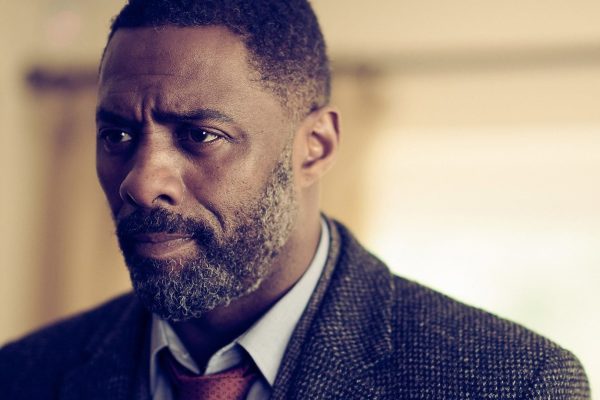 Idris Elba dans le rôle du commissaire John Luther, manteau de tweed gris, dans la série Luther